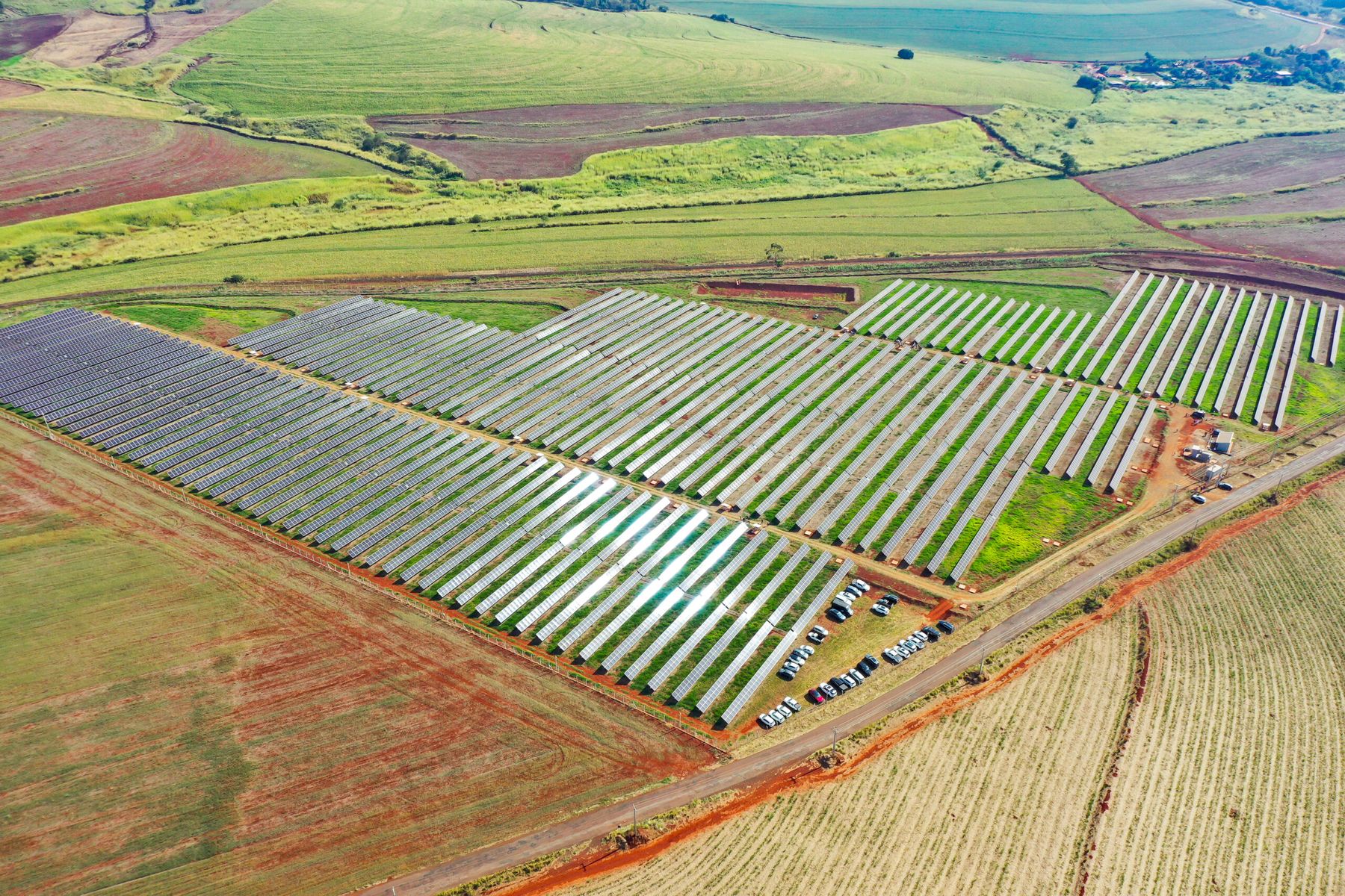 Vista aérea da UFV Aruna, usina solar da PaineiraPar no Paraná, com fileiras de painéis em campo verde